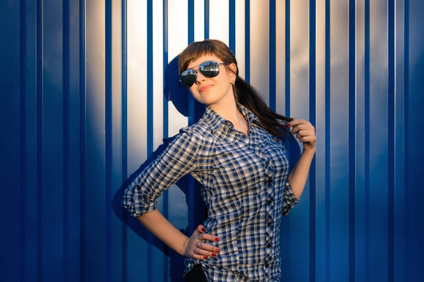 junges Mädchen mit Sonnenbrille im Hemd auf blauem Hintergrund - Foto, Bild