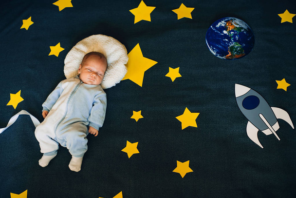 menino está dormindo e sonha-se um astronauta no espaço
 - Foto, Imagem