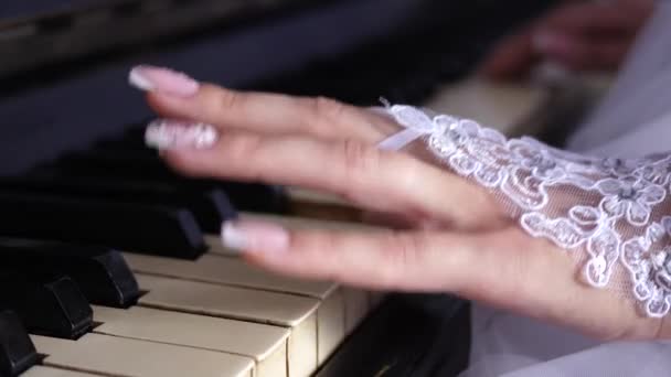 美しいマニキュアを持つ白い手袋をした少女の手がピアノを弾きます。ノートにメロディーを再生します。音楽ビジネス。クローズ アップ - 映像、動画