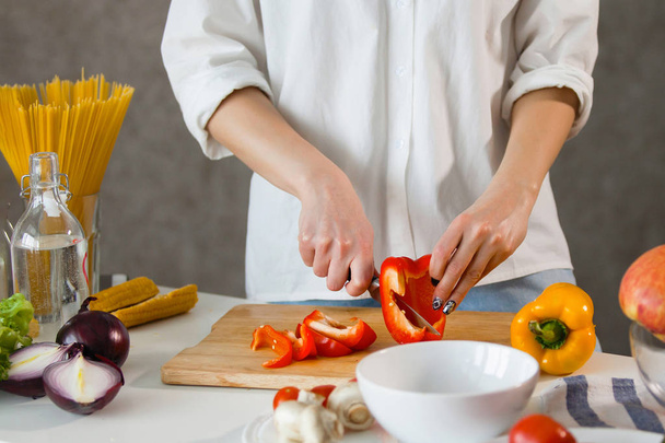 Женщина руки режет овощи на кухне
. - Фото, изображение