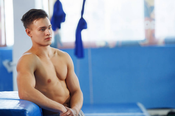Young, handsome guy is resting after a hard workout in the gym. - Photo, Image