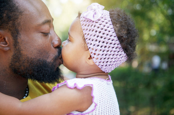 アフリカの父親は彼の腕の中に彼の小さな娘を保持し、抱擁とk - 写真・画像