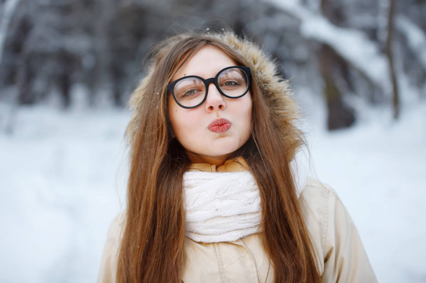 Young, pretty woman in glasses with in a snowy forest. - 写真・画像