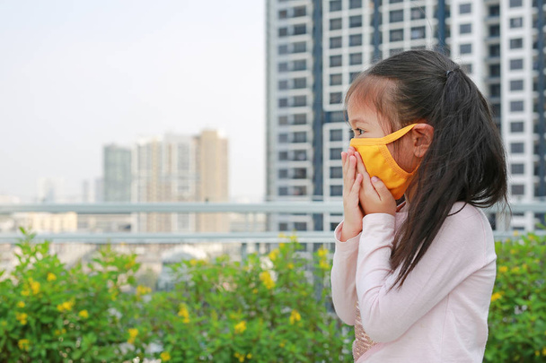 little child girl wearing a protection mask against PM 2.5 air pollution in Bangkok city. Thailand. - 写真・画像