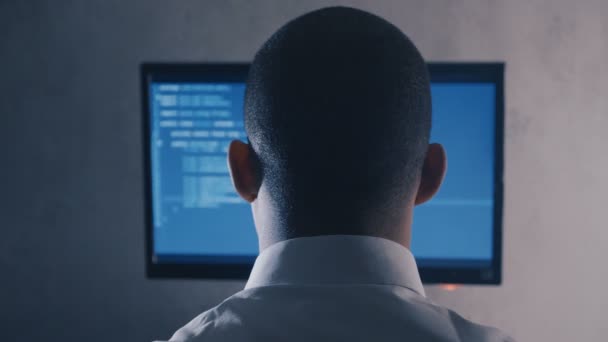 夜間オフィスのコンピュータモニタ上のプログラマプロのプログラミングコードのバックビュー - 映像、動画