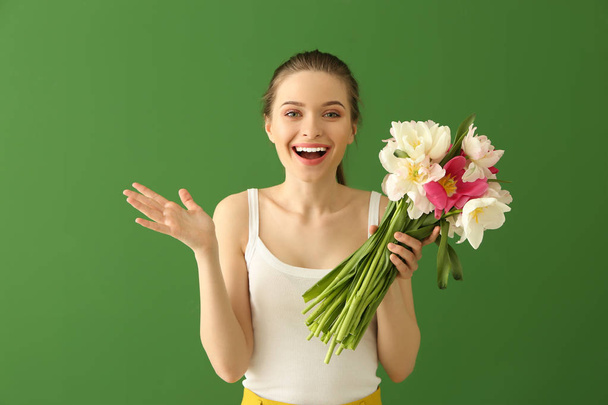 Joyeux jeune femme avec bouquet de belles tulipes sur fond de couleur
 - Photo, image