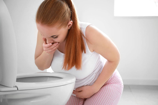 Mladá těhotná žena trpící toxikózou na toaletě - Fotografie, Obrázek