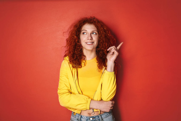 Thoughtful redhead woman on color background - Fotoğraf, Görsel