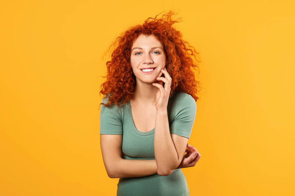 Gelukkig redhead vrouw op kleur achtergrond - Foto, afbeelding