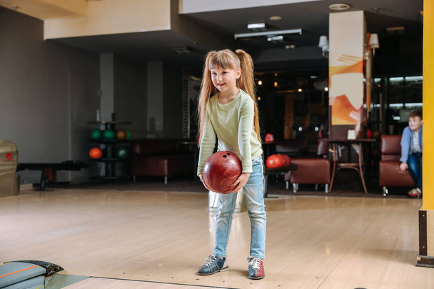 Little girl playing bowling in club - Photo, Image