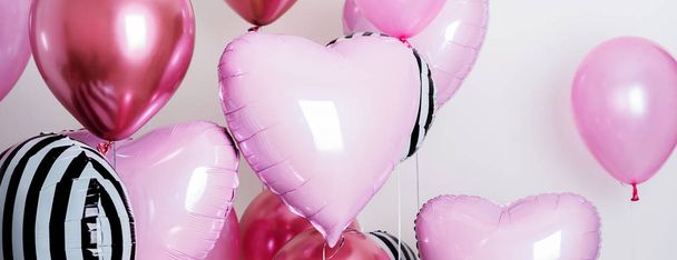 Set of pink and striped balloons in form of heart and round pink and striped on pastel pink background - Foto, Bild