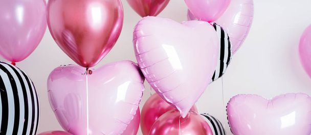 Set of pink and striped balloons in form of heart and round pink and striped on pastel pink background - Valokuva, kuva