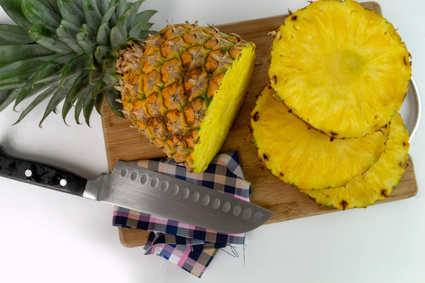 Colpo aereo di un ananas tagliato a fette su un tagliere
 - Foto, immagini