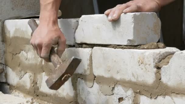 Mannelijke bouwer het leggen van witte baksteen op cement en staande muur. Handen van de mens leggen gebouw bakstenen close-up uitzicht - Video