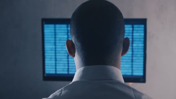 Widok z tyłu programisty profesjonalny kod programistyczny na monitorze komputerowym w biurze nocnym - Materiał filmowy, wideo
