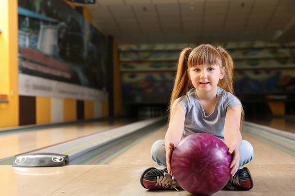 Klein meisje met bal in Bowling Club - Foto, afbeelding