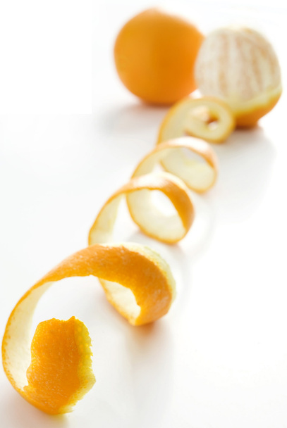 Naranja posado sobre una cáscara de naranja sobre fondo blanco
 - Foto, imagen
