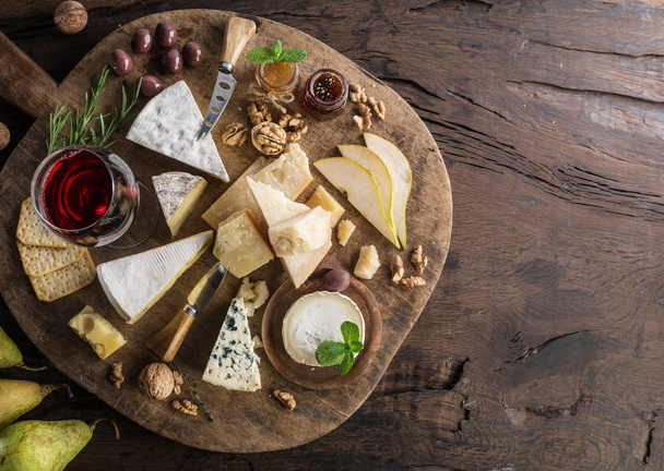 Cheese platter with organic cheeses, fruits, nuts and wine on wo - Fotoğraf, Görsel