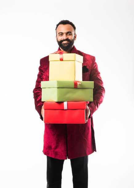 Ινδικό χαρούμενο μούσι Man σε παραδοσιακό ντύσιμο/σέργουι κρατώντας κουτί δώρου πάνω από λευκό φόντο - Φωτογραφία, εικόνα