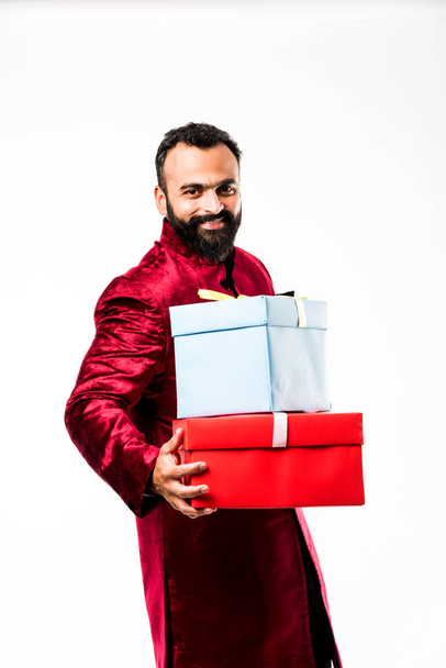 Geleneksel giyim / sherwani beyaz arka plan üzerinde hediye kutusu tutan Hint neşeli sakallı Adam - Fotoğraf, Görsel