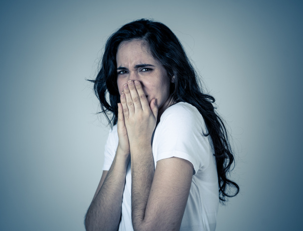 Portrait of young latin woman feeling scared and shocked making fear, anxiety gestures. Looking terrified covering herself. Copy space. In negative human expressions and emotions concept. - Foto, Bild