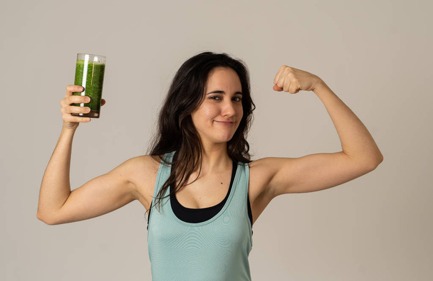 Fitness woman happy smiling holding glass of green vegetable smoothie posing happy and cute after training exercise felling fit and strong. In Body care Fitness Diet Nutrition and Healthy Lifestyle. - Fotografie, Obrázek