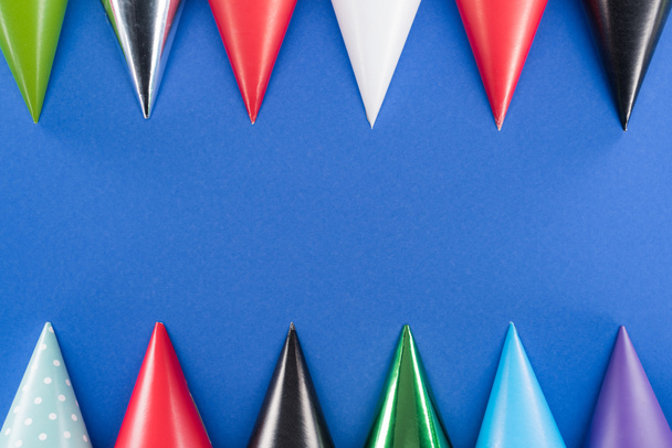 Πολύχρωμα καπέλα γενεθλίων σε μπλε φόντο με χώρο αντιγραφής - Φωτογραφία, εικόνα