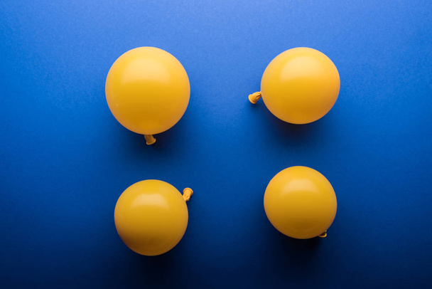 Top view of yellow balloons on blue background  - Φωτογραφία, εικόνα