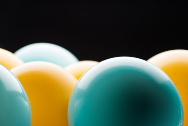 Close up view of yellow and blue bright balloons isolated on black - Foto, Imagem