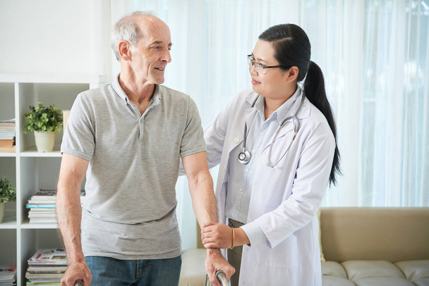 Positive young nurse visiting senior patient at home  - Photo, Image