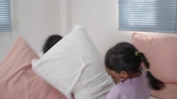 アジアの子供たちの女の子はベッドで枕の戦いを持っています. - 映像、動画