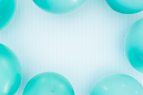 Vista superior del marco de globos azul pastel sobre fondo azul rayado
 - Foto, Imagen