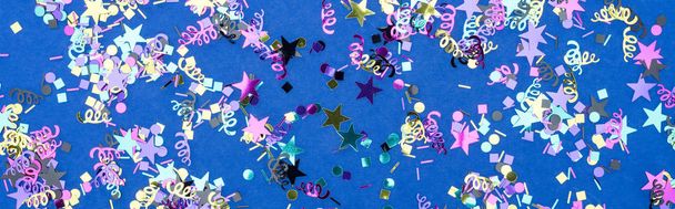 青のお祝いの背景にカラフルな紙吹雪のパノラマショット - 写真・画像