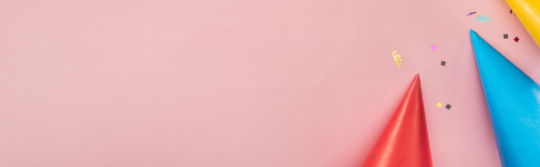 Foto panorámica de sombreros de fiesta y confeti sobre fondo rosa
 - Foto, Imagen