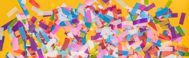 Panoramic shot of colorful confetti on yellow party background  - Фото, изображение
