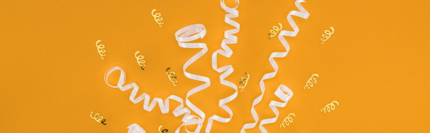 Plan panoramique de rubans blancs sur fond orange, concept de fête surprise
  - Photo, image