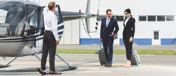 plan panoramique des partenaires d'affaires avec bagages près du pilote et de l'hélicoptère
 - Photo, image