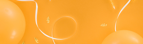 Panoramic shot of yellow balloons and party decoration on orange background - Fotografie, Obrázek