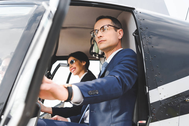 mujer de negocios y hombre de negocios sentado en cabina de helicóptero
 - Foto, Imagen