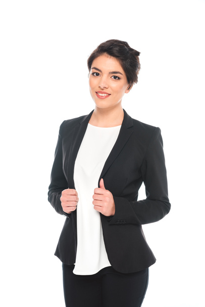 attractive mixed race businesswoman in formal wear smiling at camera isolated on white - Valokuva, kuva
