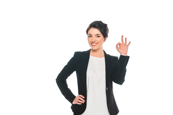 cheerful mixed race businesswoman showing ok gesture isolated on white - Фото, зображення