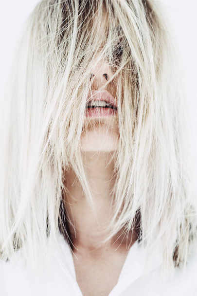 Yüzünü kaplayan sarı saçlı güzel kadının yakın portresi - Fotoğraf, Görsel