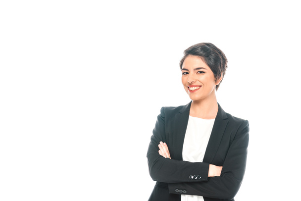 cheerful mixed race businesswoman standing with crossed arms and smiling at camera isolated on white - Photo, Image
