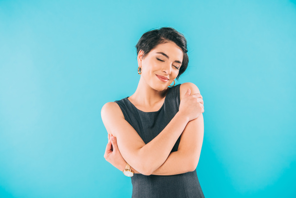 beautiful mixed race woman posing at camera with closed eyes isolated on blue - Photo, Image