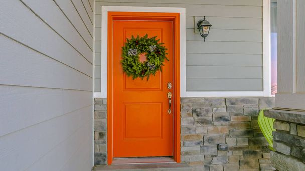 Καθαρό πανόραμα σπίτι με ένα καλωσόρισμα στεφάνι στην πορτοκαλί μπροστινή πόρτα - Φωτογραφία, εικόνα