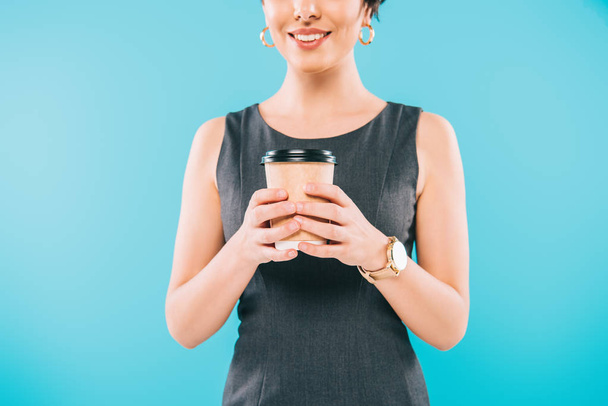 cropped shot of smiling mixed race woman holding disposable cup isolated on blue - Foto, immagini