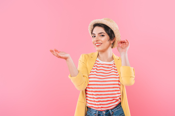 attraente ragazza razza mista in cappello di paglia posa a macchina fotografica isolato su rosa
 - Foto, immagini