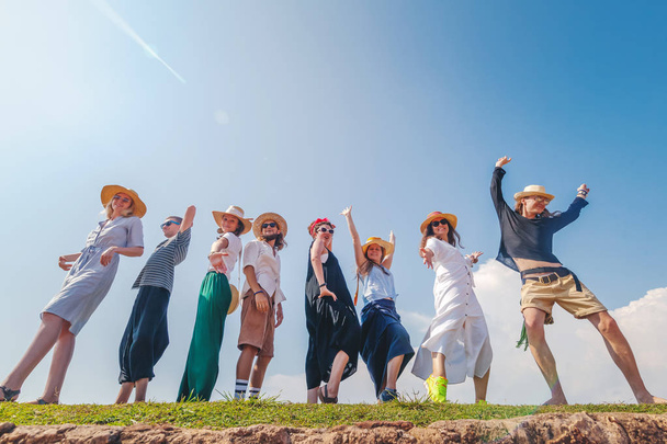 Group of happy joyful young stylish people against blue sky, friendship, community values, - Photo, Image