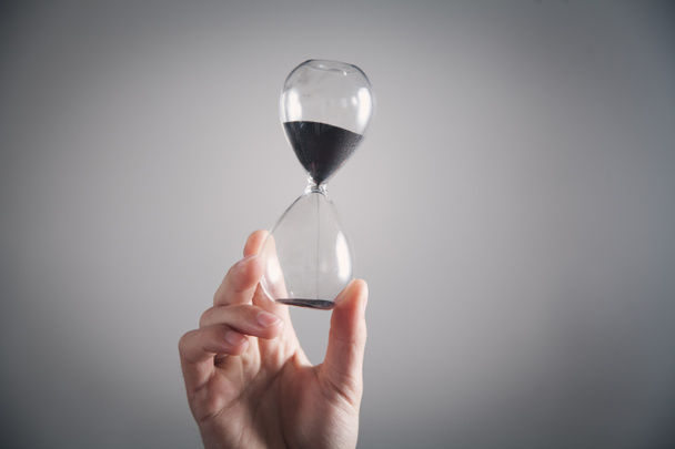 Hand holding hourglass. Deadline concept - Фото, изображение