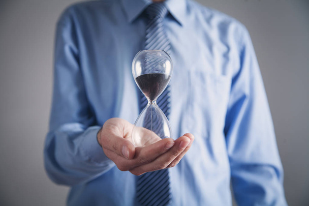 Businessman holding hourglass. Deadline concept - Photo, Image